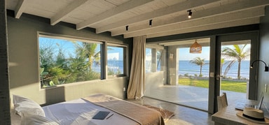 Cama de casal e quarto com vista para o mar