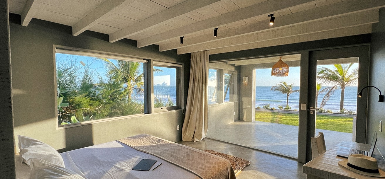 Cama de casal e quarto com vista para o mar