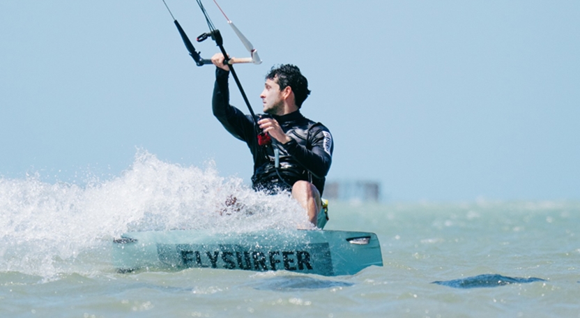 Instrutor de kitesurf pilotando a pipa durante aula na praia de Icaraizinho